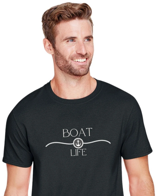 A smiling man wearing a black crewneck t-shirt with a white graphic that reads 'BOAT LIFE' and features an anchor motif, set against a plain white background.