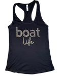 Black women's racerback tank top featuring the phrase "boat life" in sparkling rhinestone lettering. The word "boat" is displayed in lowercase block letters, with "life" in a cursive script beneath it. The tank top is laid flat on a black-and-gray checkered background.