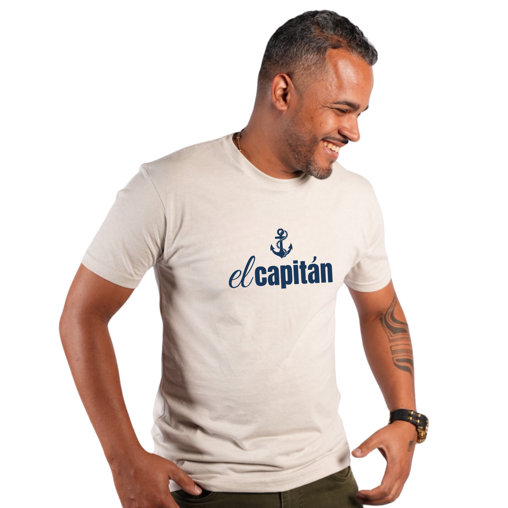 A man wearing a light beige crewneck t-shirt with a navy blue anchor graphic and the text 'el capitán' printed on the chest, set against a plain white background.