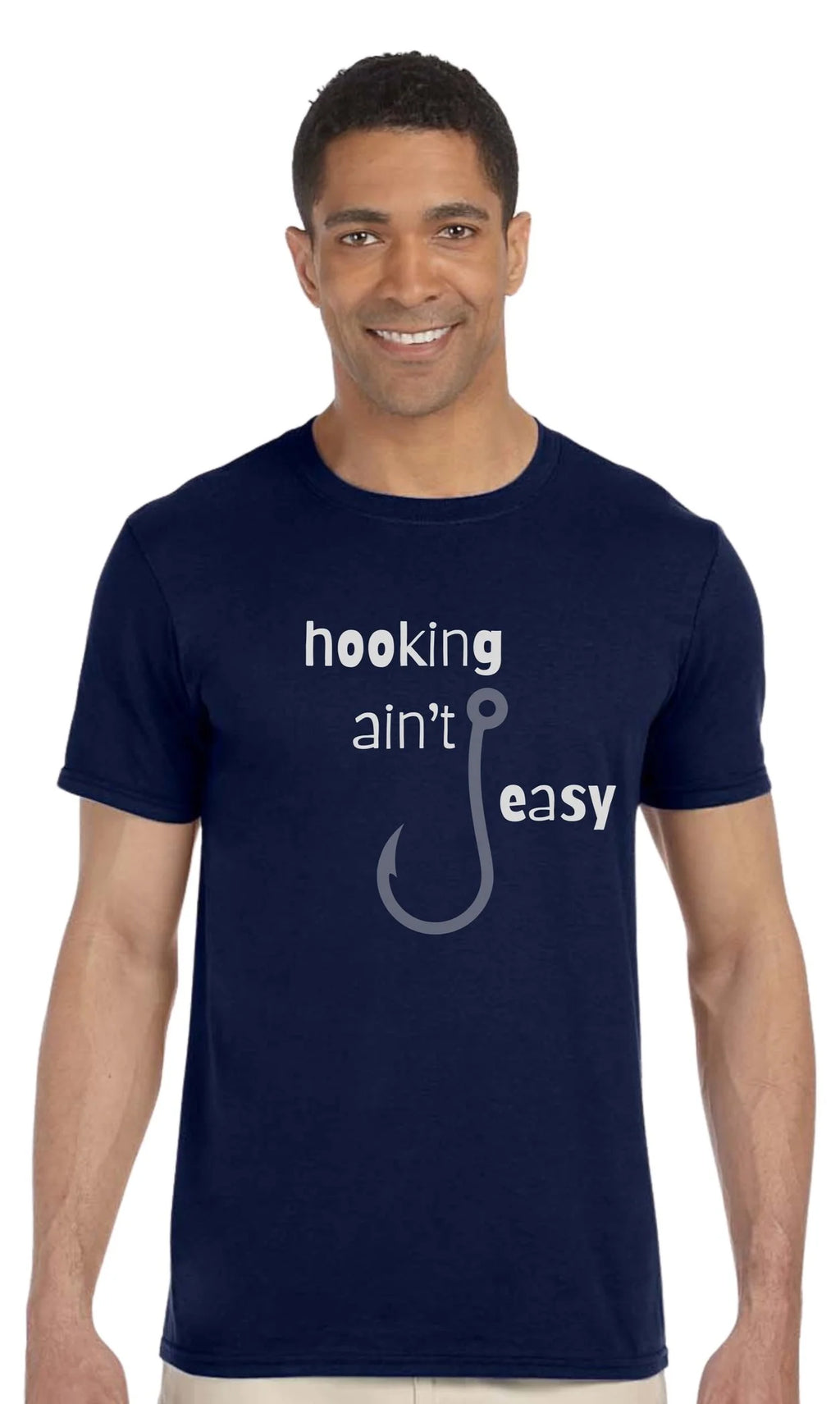 A man wearing a navy blue t-shirt with a white and gray graphic that reads 'hooking ain't easy' with a fishing hook illustration, set against a plain white background.