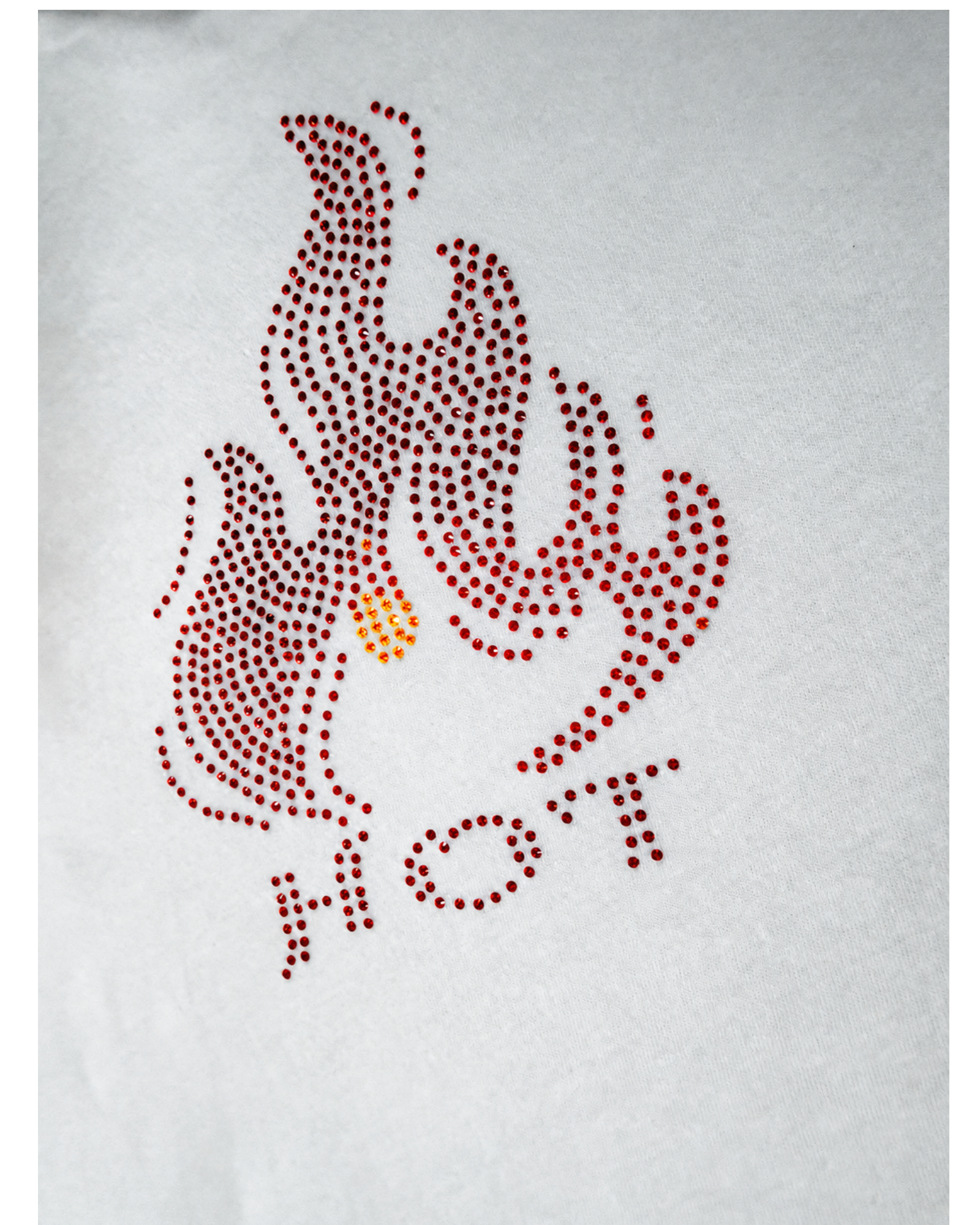 A rhinestone or dot graphic design on a white fabric background, featuring a stylized flame motif in red and orange with the word 'HOT' underneath in red dots.