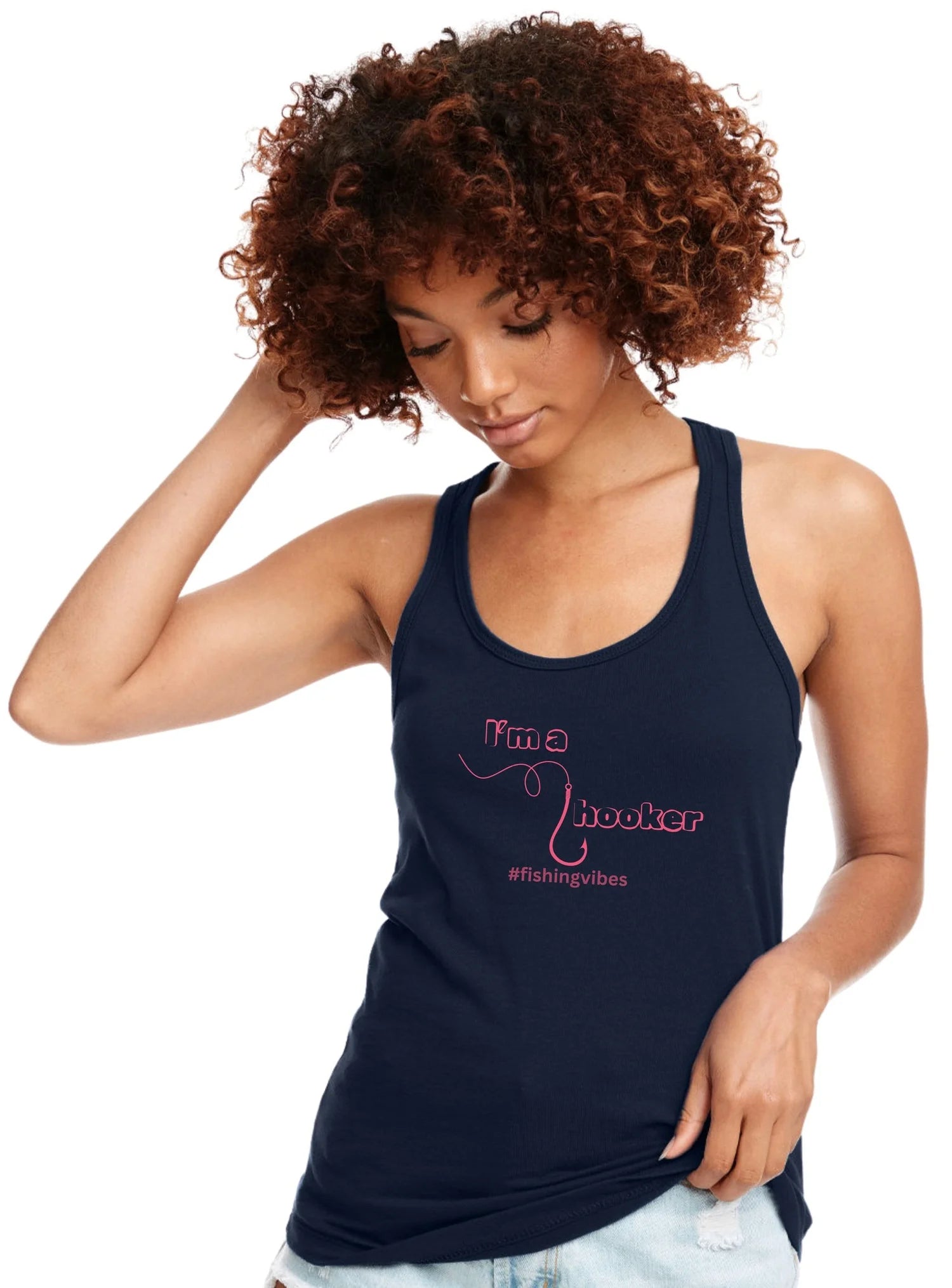 A woman with curly brown hair wearing a navy blue racerback tank top with a pink graphic that reads 'I'm a Hooker' and '#fishingvibes'.