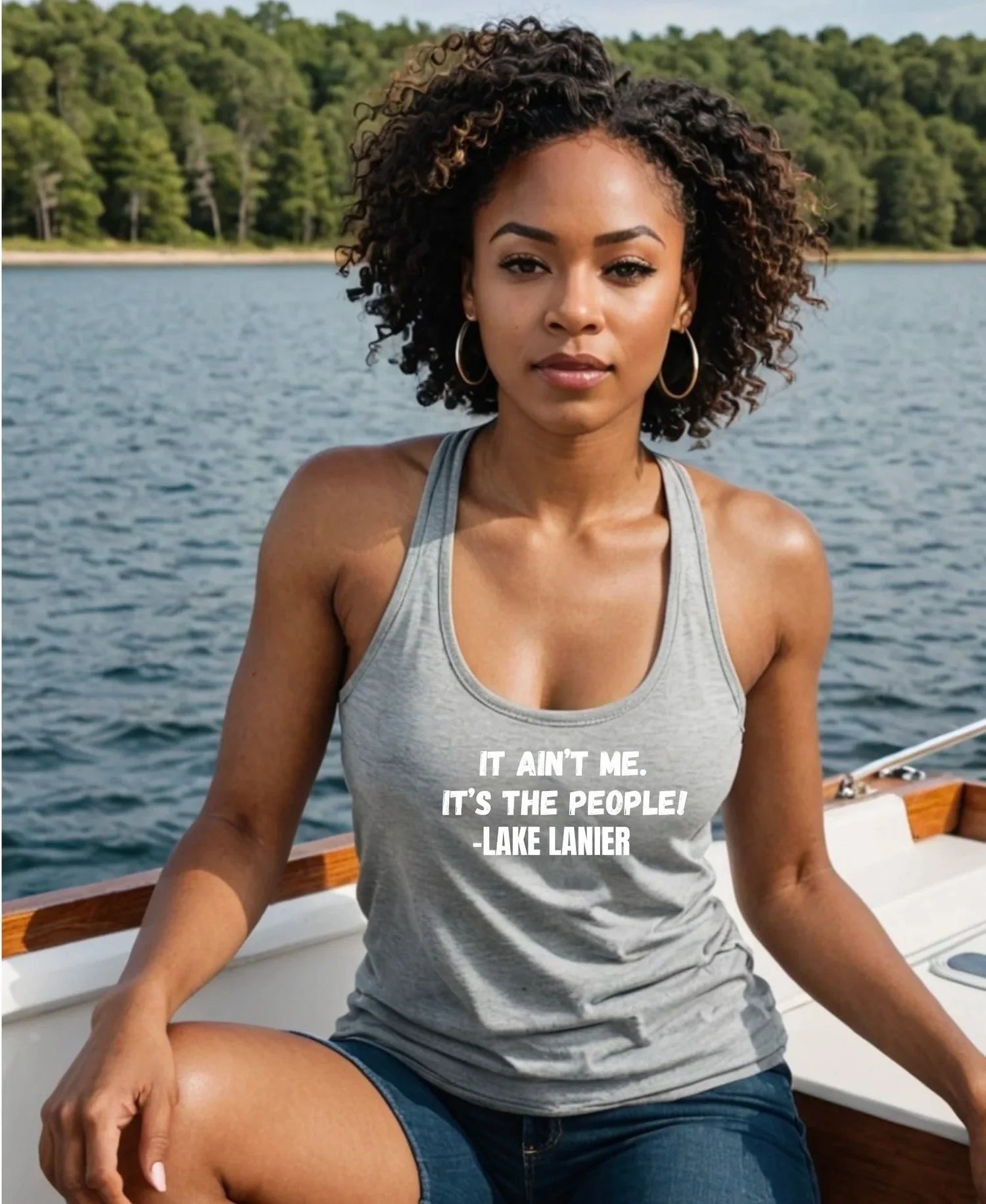  woman sitting on a boat deck with a lake and forest in the background, wearing a gray tank top with the white printed text 'IT AIN'T ME, IT'S THE PEOPLE! -LAKE LANE!'.