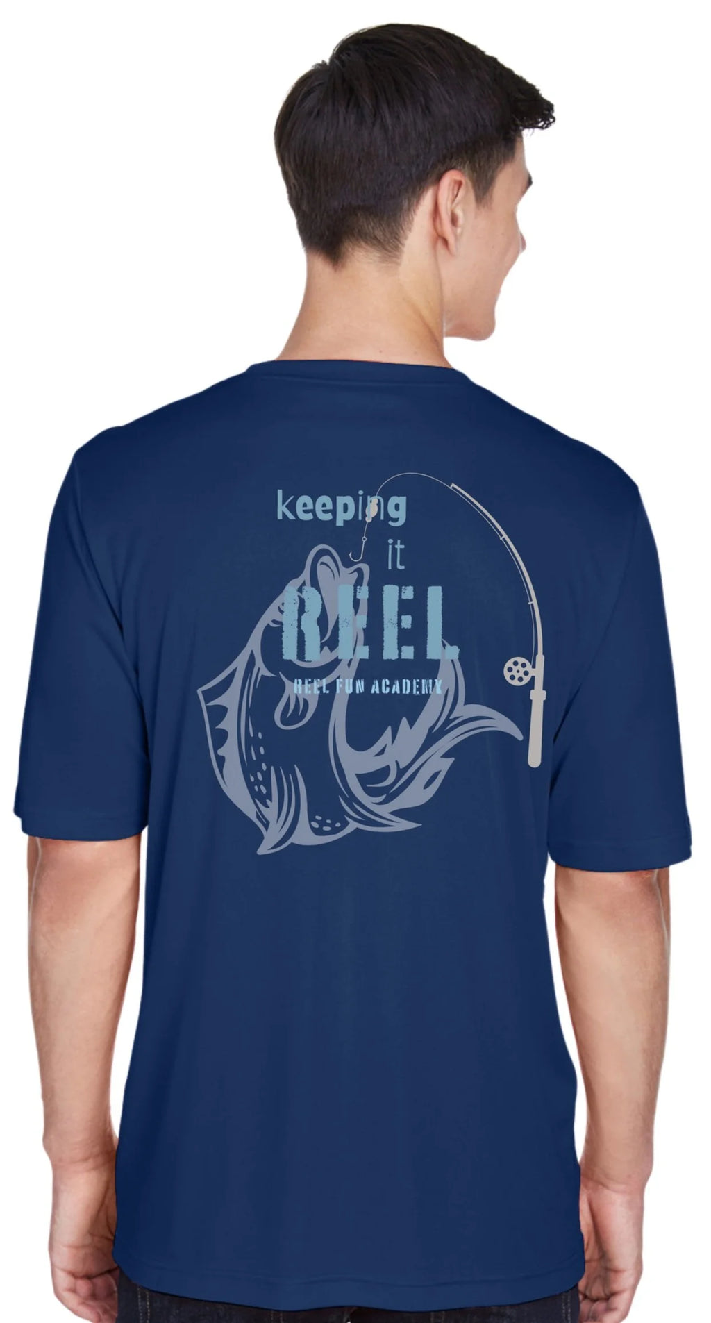 A man shown from the back wearing a navy blue t-shirt with a light blue graphic of a fishing rod and fish and the text 'keeping it REEL' and Reel Fun Academy.