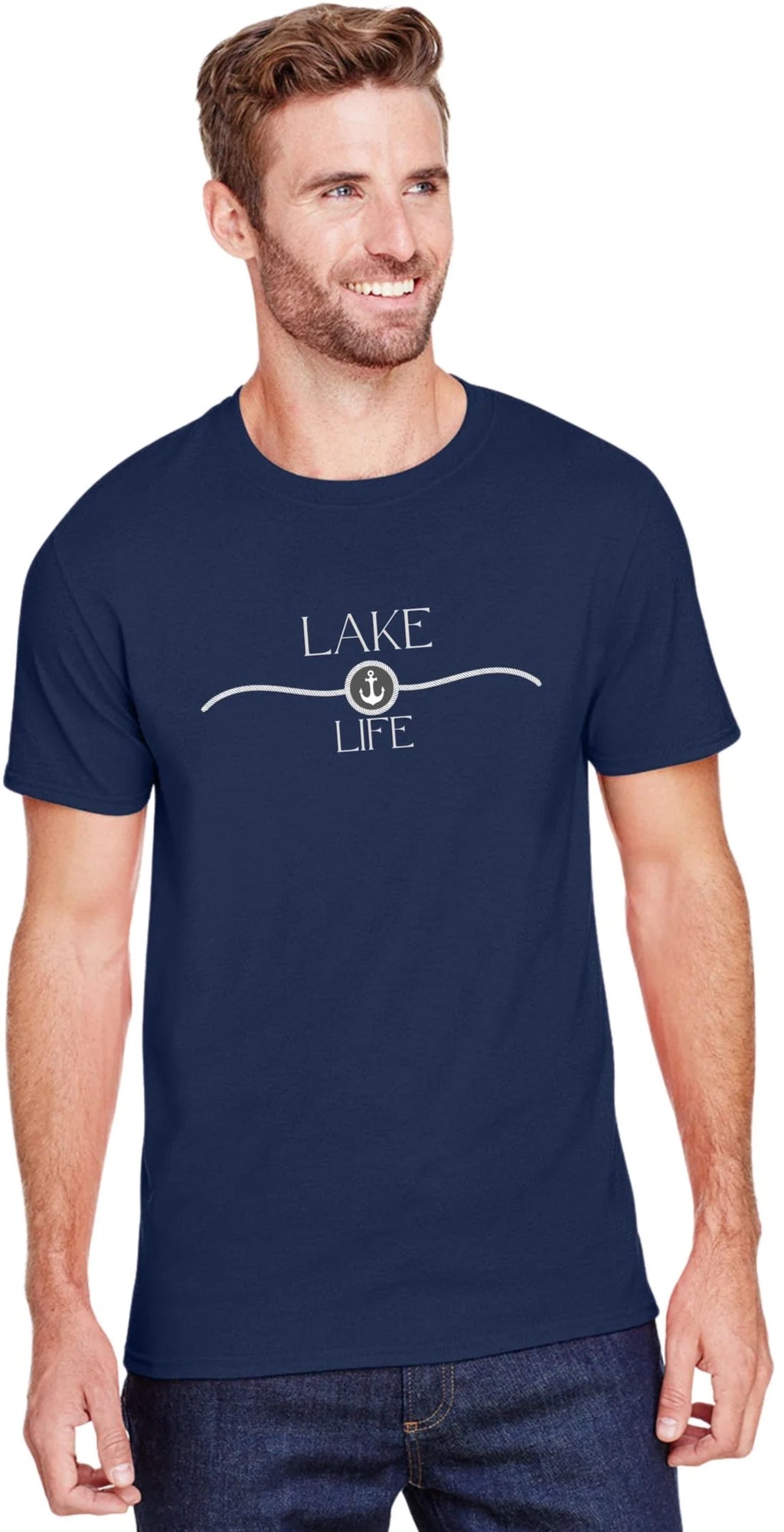 A man wearing a navy blue crewneck t-shirt with a white graphic that reads 'LAKE LIFE' and an anchor design, paired with dark blue jeans against a plain white background.