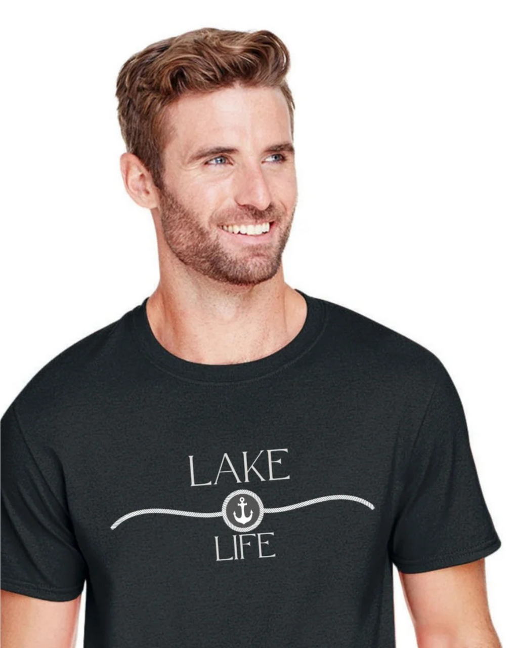 A smiling man with short brown hair and a beard wearing a dark charcoal gray crewneck t-shirt with a white graphic that reads 'LAKE LIFE' and an anchor symbol, set against a plain white background.