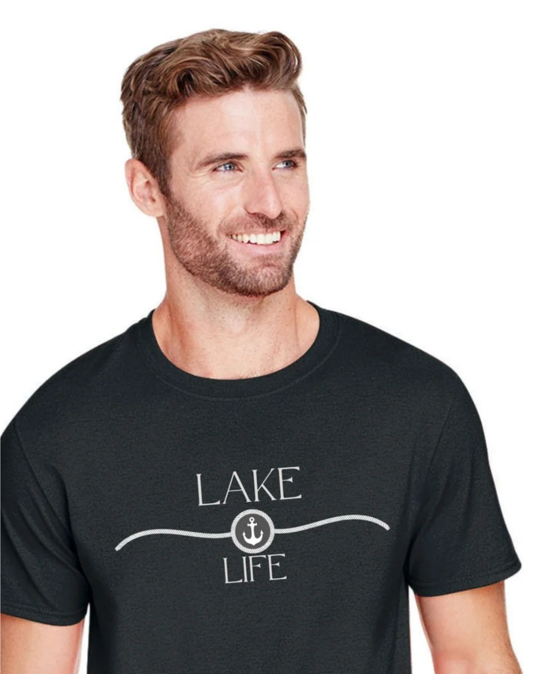 A smiling man with short brown hair and a beard wearing a dark charcoal gray crewneck t-shirt with a white graphic that reads 'LAKE LIFE' and an anchor symbol, set against a plain white background.