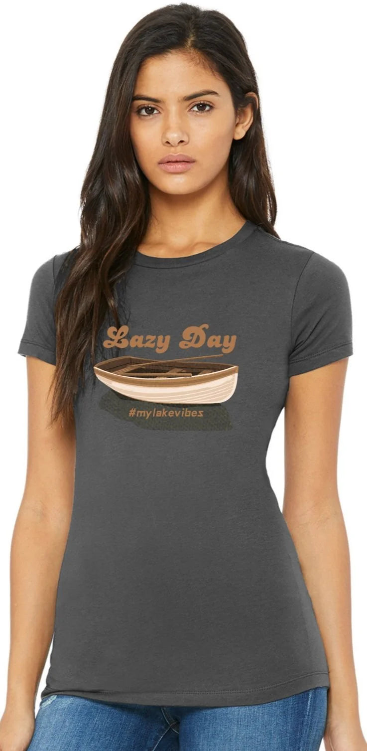 A woman modeling a dark gray t-shirt with a graphic that reads 'Lazy Day and mylakevibes' above and below a drawing of a canoe.