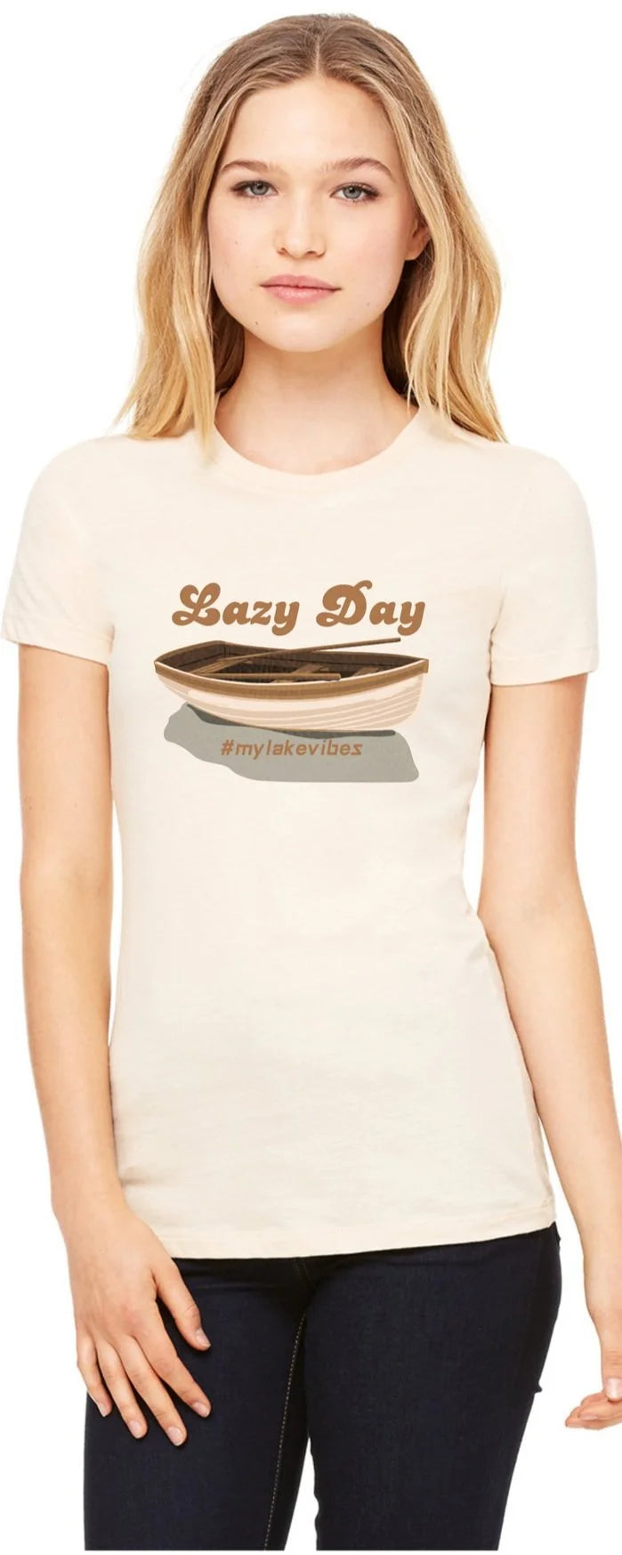 A woman modeling a cream heathered t-shirt with a graphic that reads 'Lazy Day' and 'mylakevibes' below it, set against a plain white background.