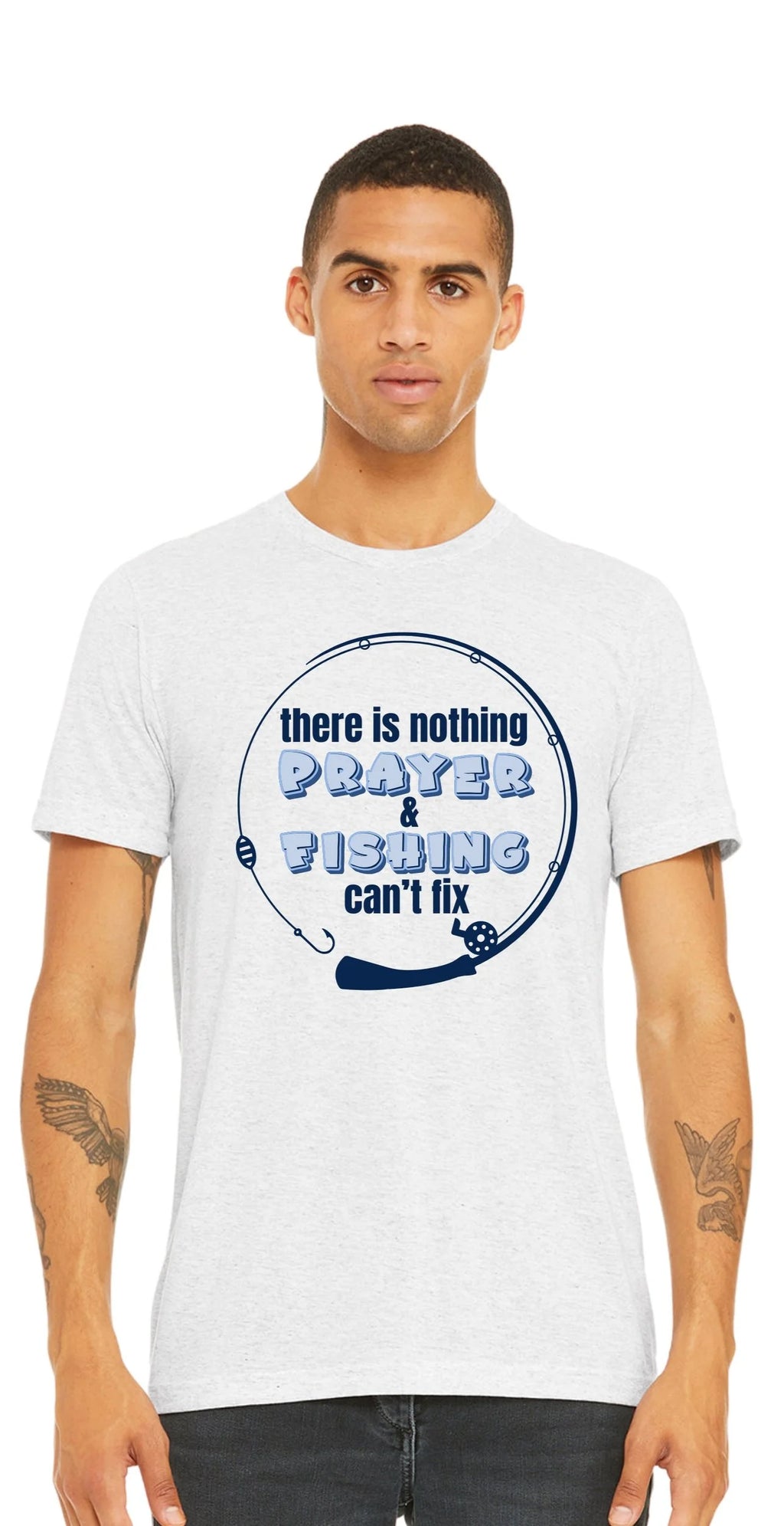 A man wearing a white crewneck t-shirt with a blue circular fishing rod graphic that reads 'there is nothing PRAYER & FISHING can't fix' on a plain white background.
